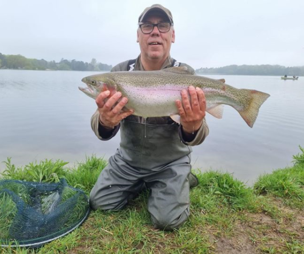 a man proudly holding a large fish he has caught